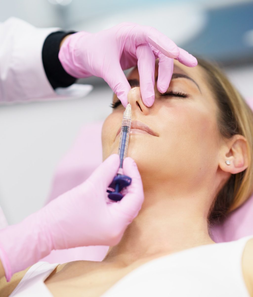 doctor-performing-rhinoplasty-by-injection-of-hyaluronic-acid-in-the-nose-of-his-patient-1.jpg